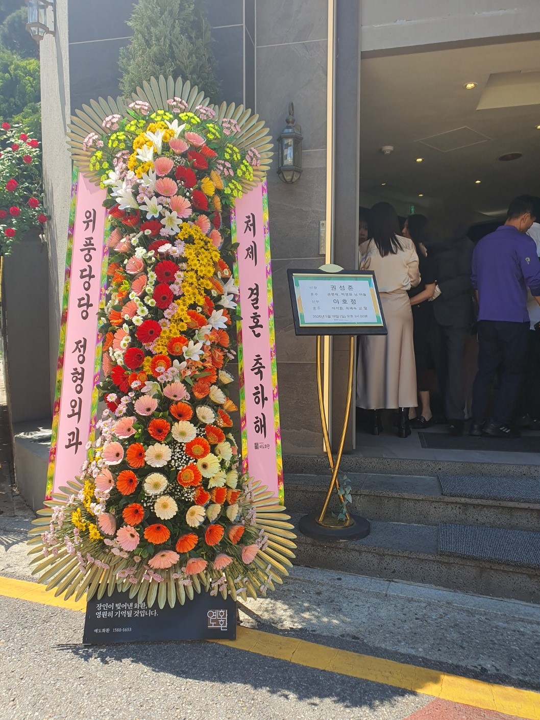 예도화환 리본 글씨 출력 후 화환에 부착하여 검수하는 모습